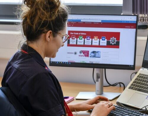 Image shows a FRS staff member typing on a computer keyboard